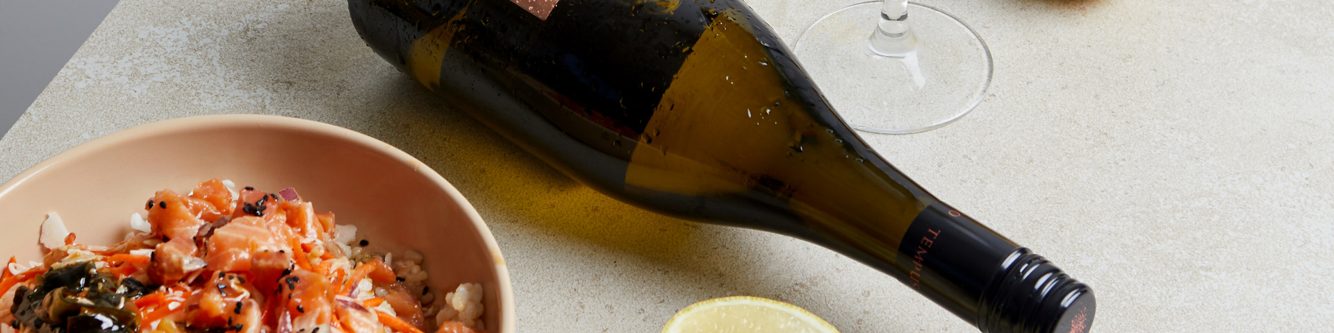 Bottle of Tempus Two Varietal with a bowl of salmon, rice and vegetables